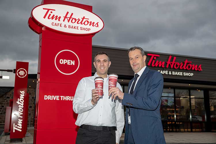 Graeme Tobias (L), owner of Pizza Cake, and Grant Bett (R), Relationship Director at HSBC UK, toast the new Drive Thru Tim Hortons in Stenhousemuir