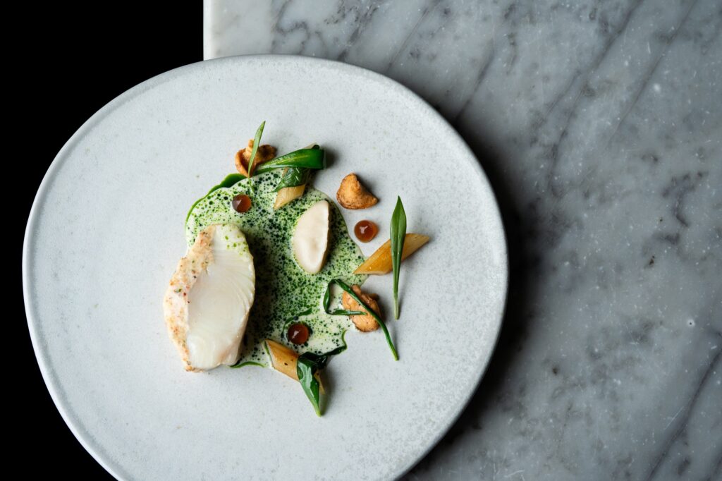 Halibut, pancetta, wild garlic, salsify puree, hedgehog mushrooms, halibut bone sauce (Credit: Jenny Jones Photography)
